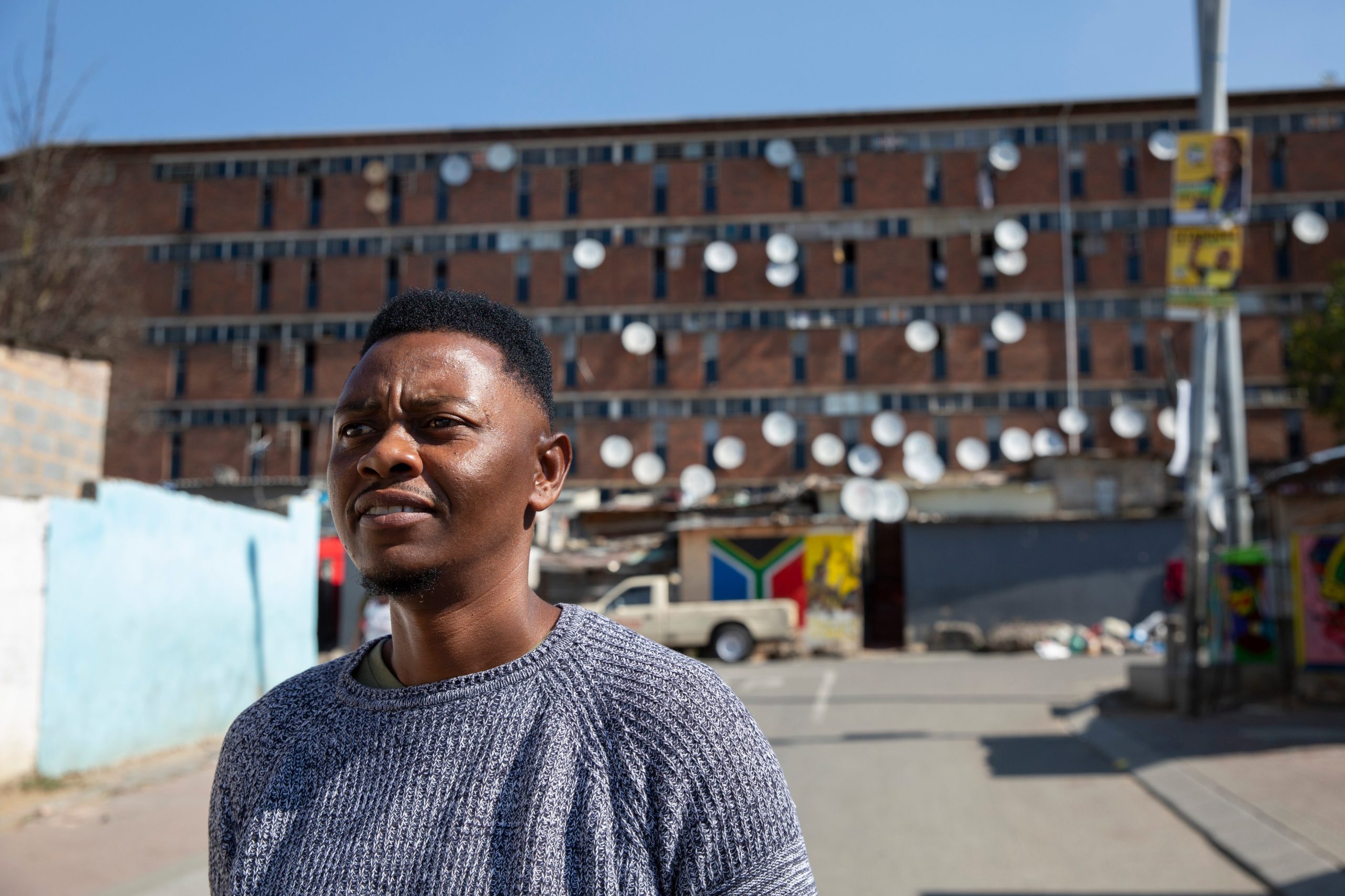 Israel Muthabula, de 36 años, frente a un albergue para mujeres de la era del apartheid en Alexandra